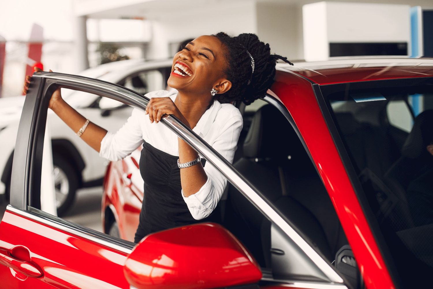 Happy woman getting out of a car after a test drive