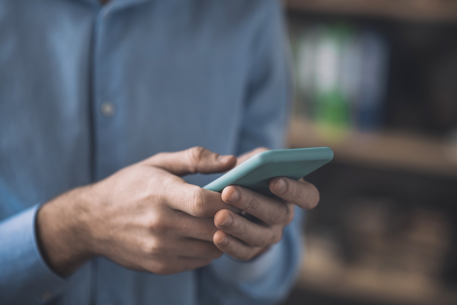 Man holding phone with blurry background and gloomy tint